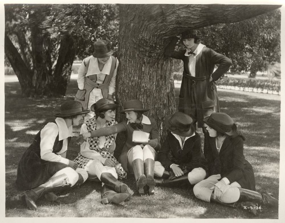 Zasu Pitts stiing with other actors under tree