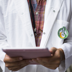 Person in lab coat holding tablet