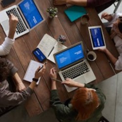 Photo taken from overhead of a table with laptops on it