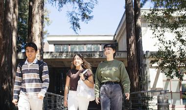 three students in front of the science and engineering library