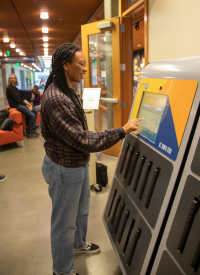 Students checks out laptop at new computer Kiosk at McHenry Library