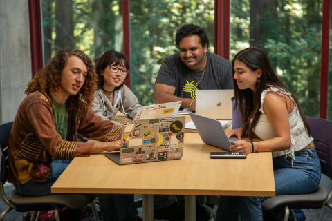 Students at table working on laptops