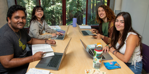 students sitting at table in the library