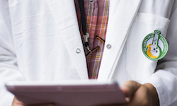 Person in lab coat holding tablet