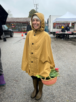 Annette Marines in yellow poncho holding basket of flowers