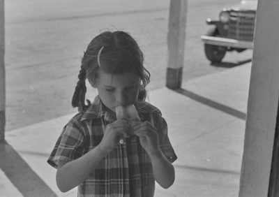 B&W image of young girl eating a popsicle